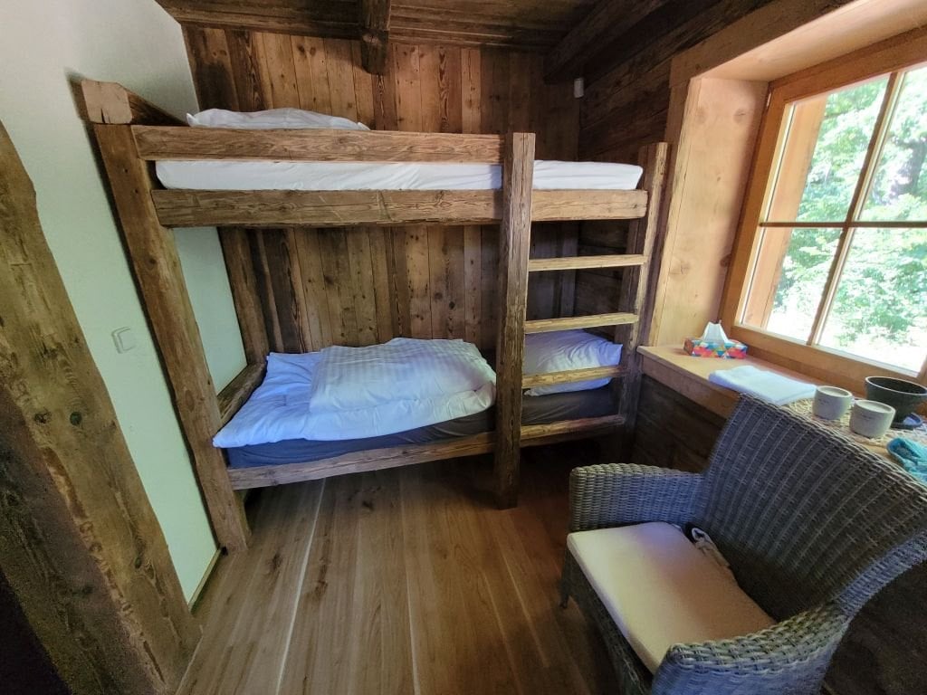 Familienzimmer mit Holz-Etagenbett und Fenster zum Wald