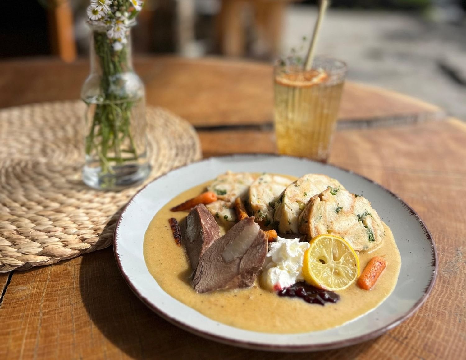 Svíčková mit Semmelknödel und Limonade auf einem Holztisch